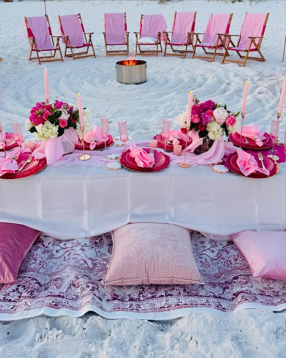 Elegant beach event setup with bonfire and decorations
