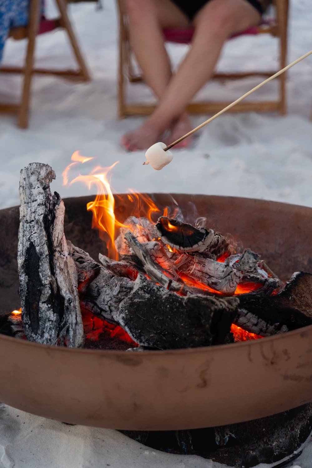 Marshmallow roasting over bonfire on the beach
